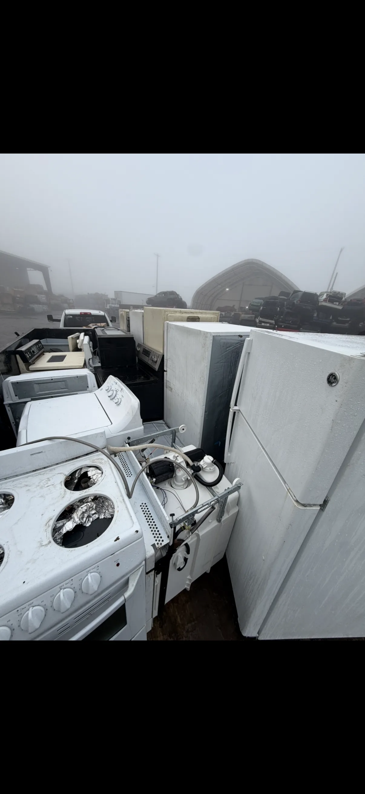 Row of refrigerators, stoves, and washers lined up for disposal