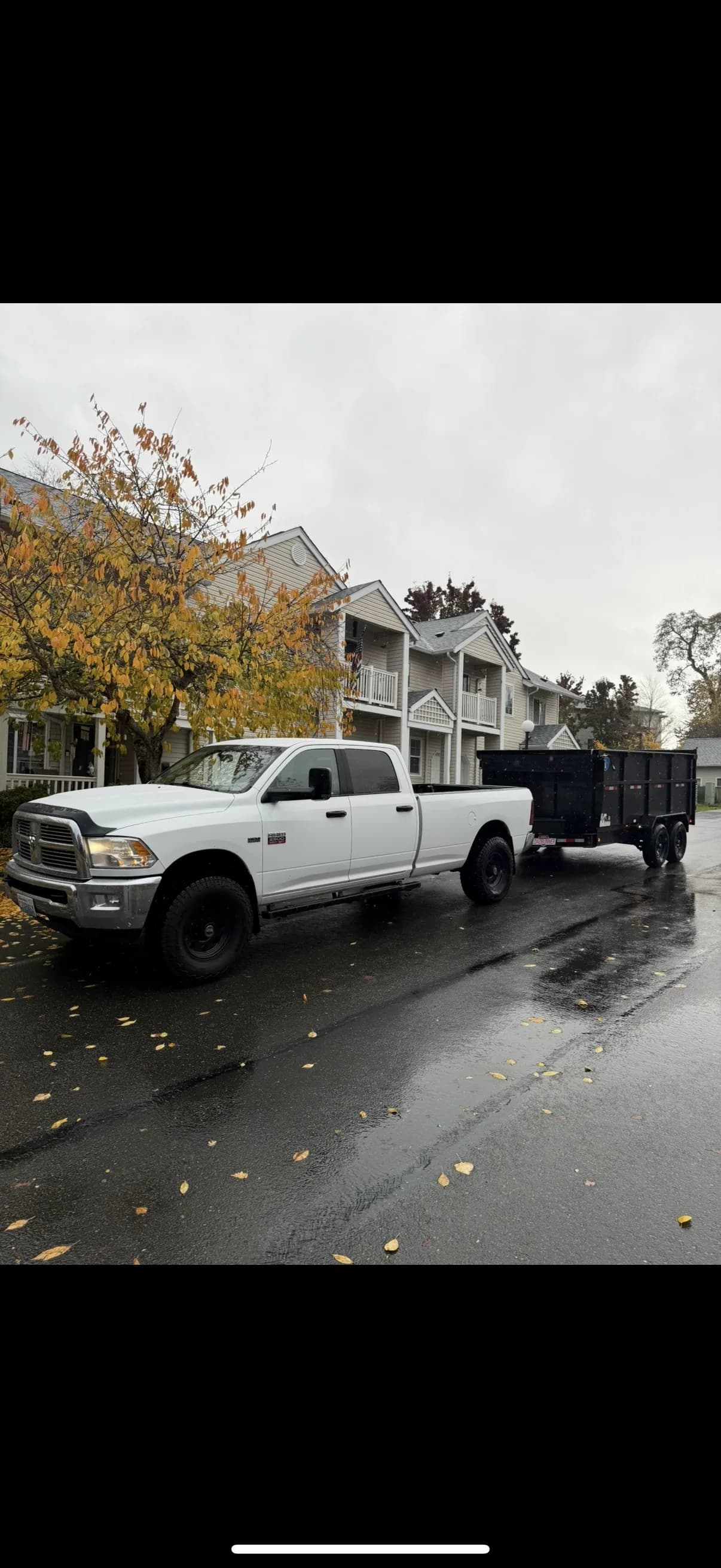 Top Tier white truck and trailer parked in residential neighborhood